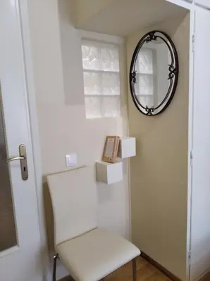 a white chair and a mirror in a room at Kerameikos residence in Athens