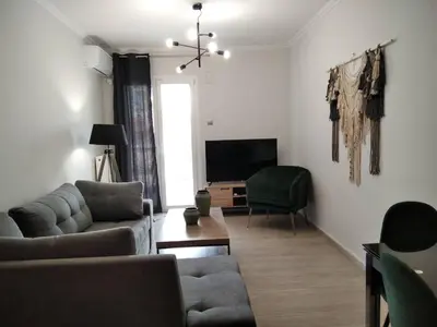 a living room with two couches and a television at Blue Flag Glyfada Center in Athens