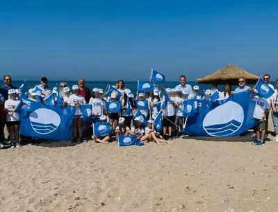 a group of people on the beach with a blue banner at Blue Flag Glyfada Center in Athens