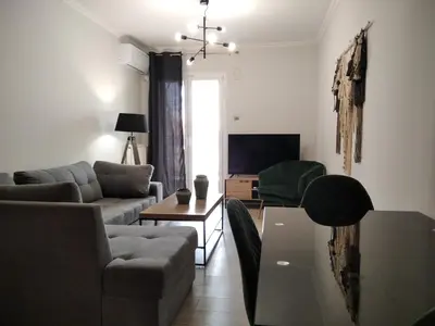 a living room with a couch and a table at Blue Flag Glyfada Center in Athens