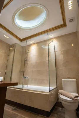a bathroom with a shower with a toilet and a tub at Royal Apartment in Athens