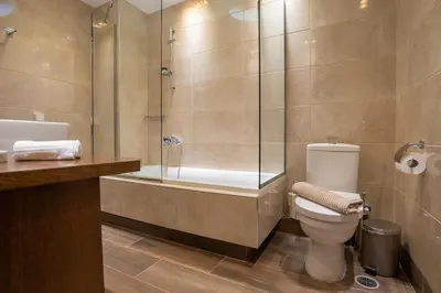 a bathroom with a shower and a toilet and a tub at Royal Apartment in Athens