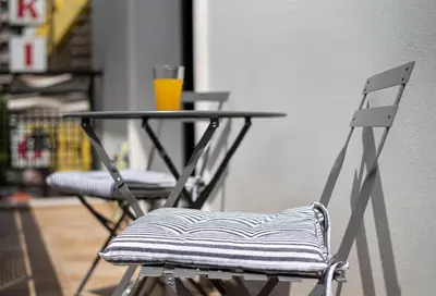 a table and chairs with a glass of orange juice at Royal Apartment in Athens