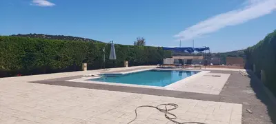 a swimming pool with a hose next to a fence at Evelina's suite in Artemida