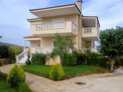 a large house with a garden in front of it at Evelina's suite in Artemida