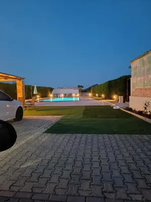 a parking lot with a lawn at night at Evelina's suite in Artemida