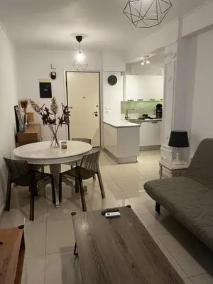 a living room with a table and a kitchen at ALKYONI in Athens