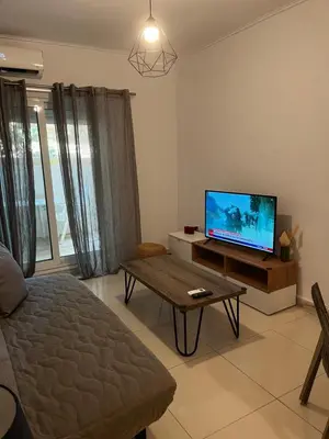 a living room with a tv and a coffee table at ALKYONI in Athens