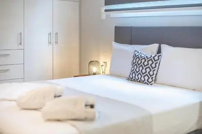 a bedroom with two beds with white sheets and pillows at The Boutique Studio by CloudKeys in Athens