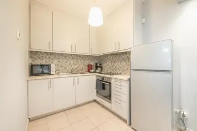 a kitchen with white cabinets and a refrigerator at The Boutique Studio by CloudKeys in Athens