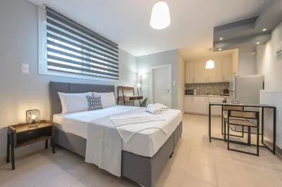 a bedroom with a large bed and a kitchen at The Boutique Studio by CloudKeys in Athens