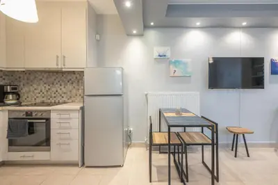 a kitchen with a refrigerator and a table with chairs at The Boutique Studio by CloudKeys in Athens