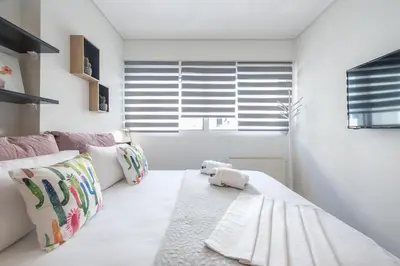 a white room with a white couch and a window at Elegant Home with Balcony by CloudKeys in Athens