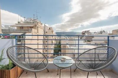 a balcony with two chairs and a glass table at Elegant Home with Balcony by CloudKeys in Athens