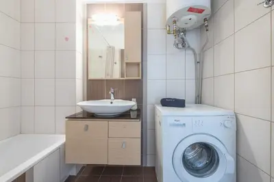 a bathroom with a washing machine and a sink at Elegant Home with Balcony by CloudKeys in Athens