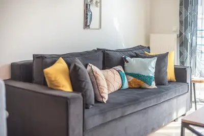 a black couch with pillows on it in a living room at Elegant Home with Balcony by CloudKeys in Athens