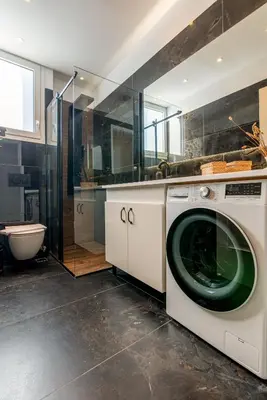 a white washing machine in a bathroom with a toilet at Athenian Serene City Escape in Athens