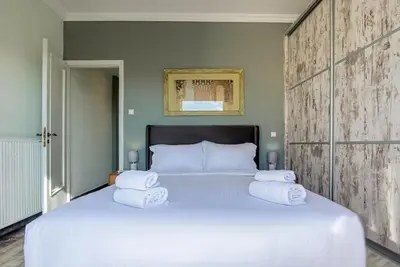a bedroom with a large bed with towels on it at Athenian Serene City Escape in Athens