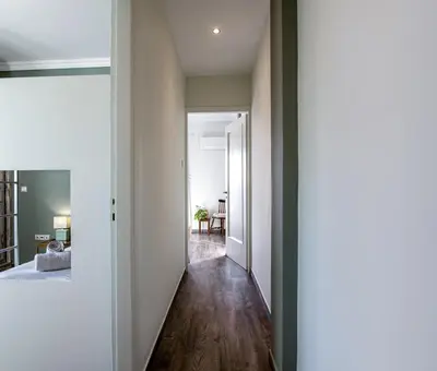 a hallway leading to a living room with wood floors at Athenian Serene City Escape in Athens