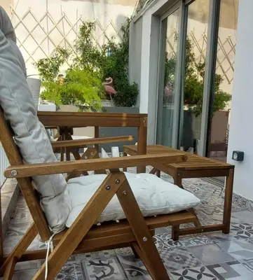 a wooden chair with a pillow on a table at Comfy penthouse in the center of Athens in Athens