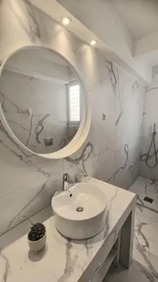 a white bathroom with a sink and a mirror at Comfy penthouse in the center of Athens in Athens