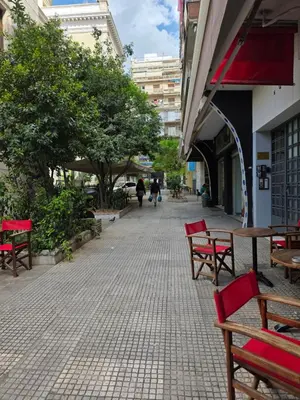a group of red benches sitting on a sidewalk at Comfy penthouse in the center of Athens in Athens