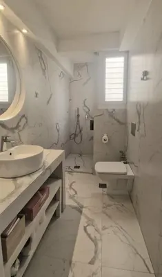 a white bathroom with a sink and a toilet at Comfy penthouse in the center of Athens in Athens