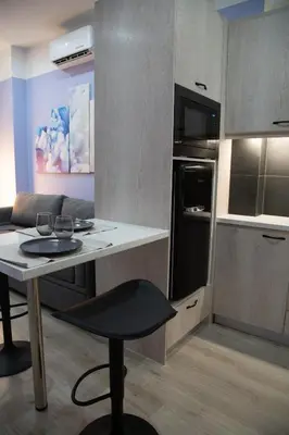 a small kitchen with a table and a chair in it at Modern Apartment Downtown Athens in Athens