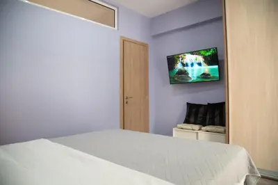 a bedroom with a bed and a tv on the wall at Modern Apartment Downtown Athens in Athens