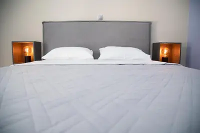 a large white bed with two lamps on either side at Modern Apartment Downtown Athens in Athens