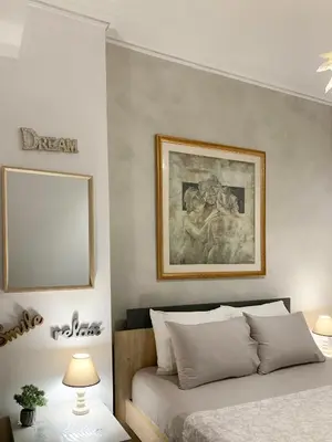 a bedroom with a bed and a picture on the wall at Cozy and Chic apartment in the Center, 5 min Subway in Athens