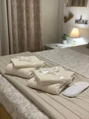 a pile of towels sitting on top of a bed at Cozy and Chic apartment in the Center, 5 min Subway in Athens