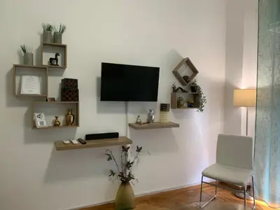 a living room with a tv on a white wall at Cozy and Chic apartment in the Center, 5 min Subway in Athens