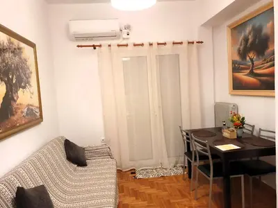 a living room with a dining room table and a desk at Success's Apartment in Athens