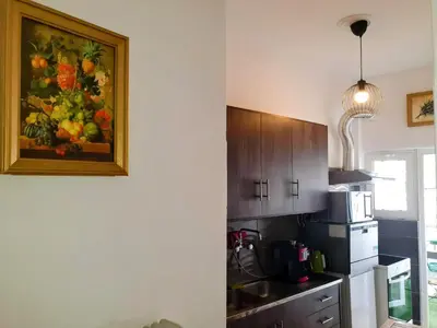 a kitchen with a painting of fruit on the wall at Success's Apartment in Athens