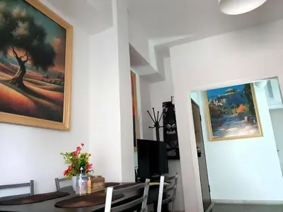 a dining room with a table and a painting on the wall at Success's Apartment in Athens