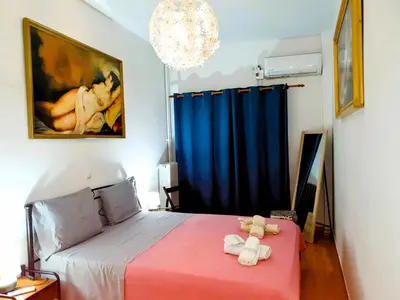 a bedroom with a bed with a blue curtain at Success's Apartment in Athens
