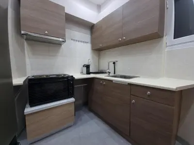 a small kitchen with wooden cabinets and a sink at CENTRAL in Athens