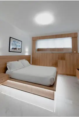 a bed with a wooden platform in a bedroom at Luxury Studio in the heart of Kolonaki in Athens