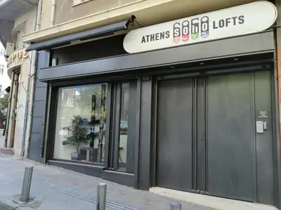 a store with glass doors on a building at Athens Soho Lofts - Super 8 in Athens