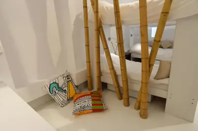 a room with two bunk beds and bamboo poles at Athens Soho Lofts - Super 8 in Athens