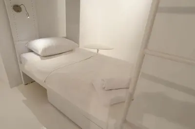 a small white room with a bed and a table at Athens Soho Lofts - Super 8 in Athens