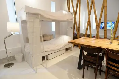 a room with a bunk bed and a wooden table at Athens Soho Lofts - Super 8 in Athens