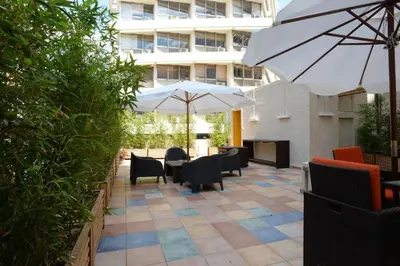 a patio with tables and chairs and an umbrella at Athens Soho Lofts - Super 8 in Athens