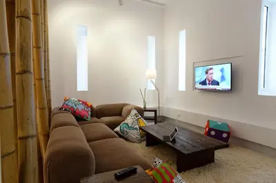 a living room with a couch and a tv on a wall at Athens Soho Lofts - Super 8 in Athens