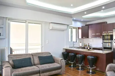 a living room with a couch and a kitchen at Luxury at its best beach condo in Palaio Faliro in Athens