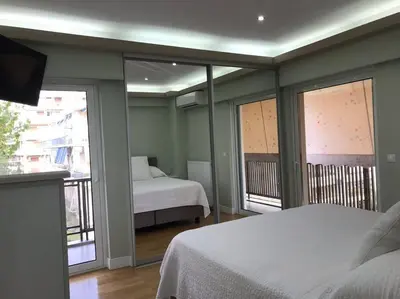 a bedroom with two beds and a balcony at Finer Things Flisvos Beach Condo in Palaio Faliro in Athens