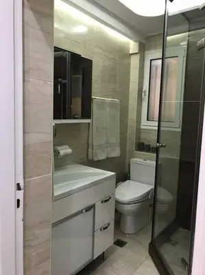a bathroom with a toilet and a sink and a shower at Finer Things Flisvos Beach Condo in Palaio Faliro in Athens