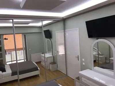 a bedroom with a bed and a tv on the wall at Finer Things Flisvos Beach Condo in Palaio Faliro in Athens