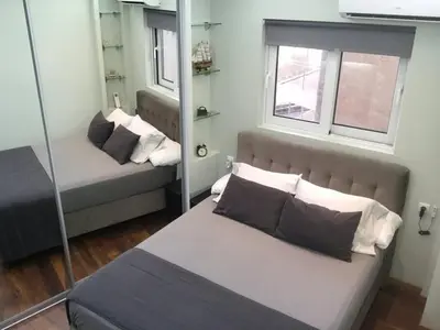 a small bedroom with a bed and a mirror at Finer Things Flisvos Beach Condo in Palaio Faliro in Athens